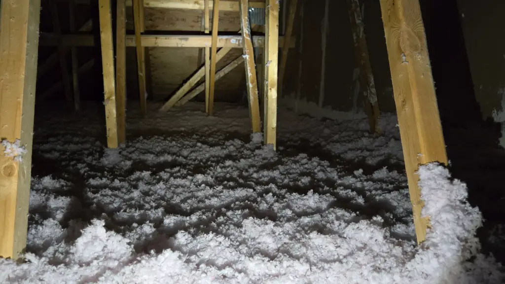 Disturbed loose-fill attic insulation exposing roof framing during inspection