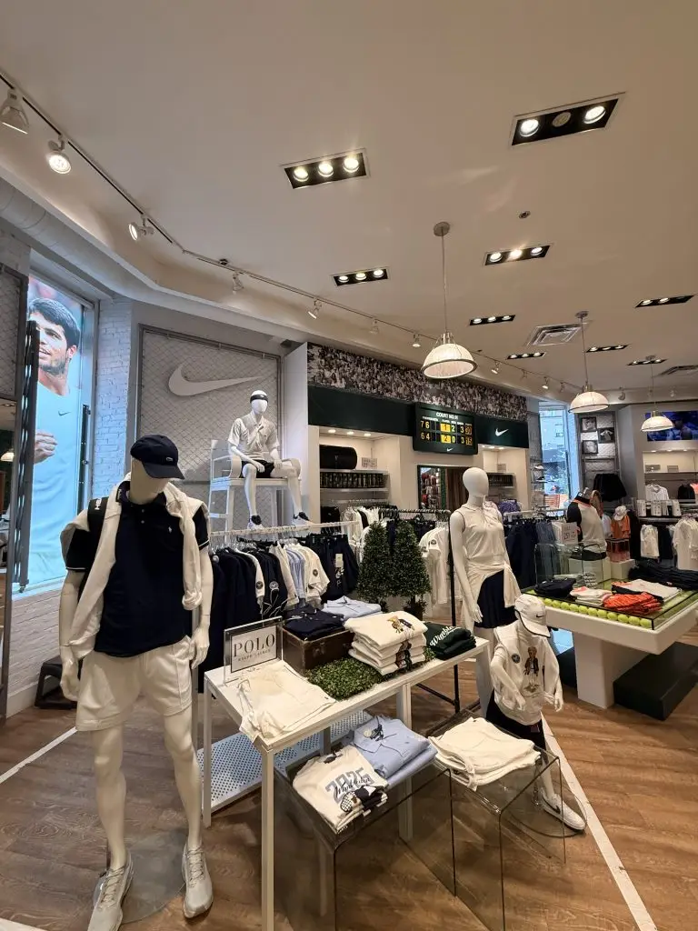Completed apparel retail interior with display tables, track lighting and feature wall