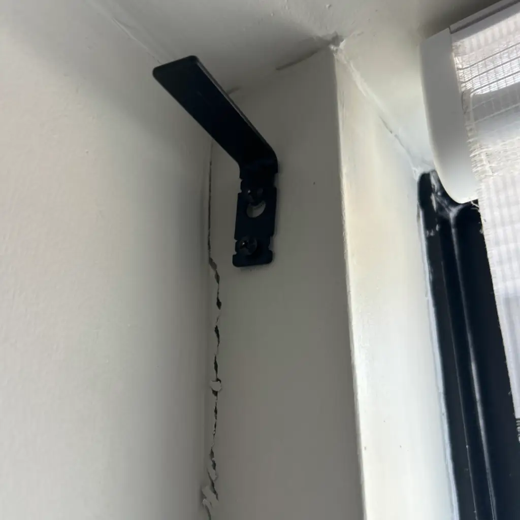 Settlement crack running down a wall beside a window frame in a new-build home
