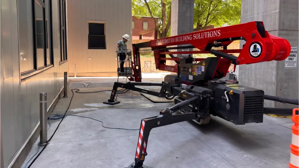 UBS-branded spider lift set up with a worker in the basket during on-site building access work